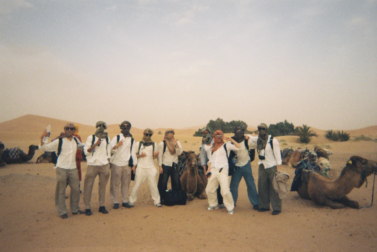 Friends beside camels in the desert