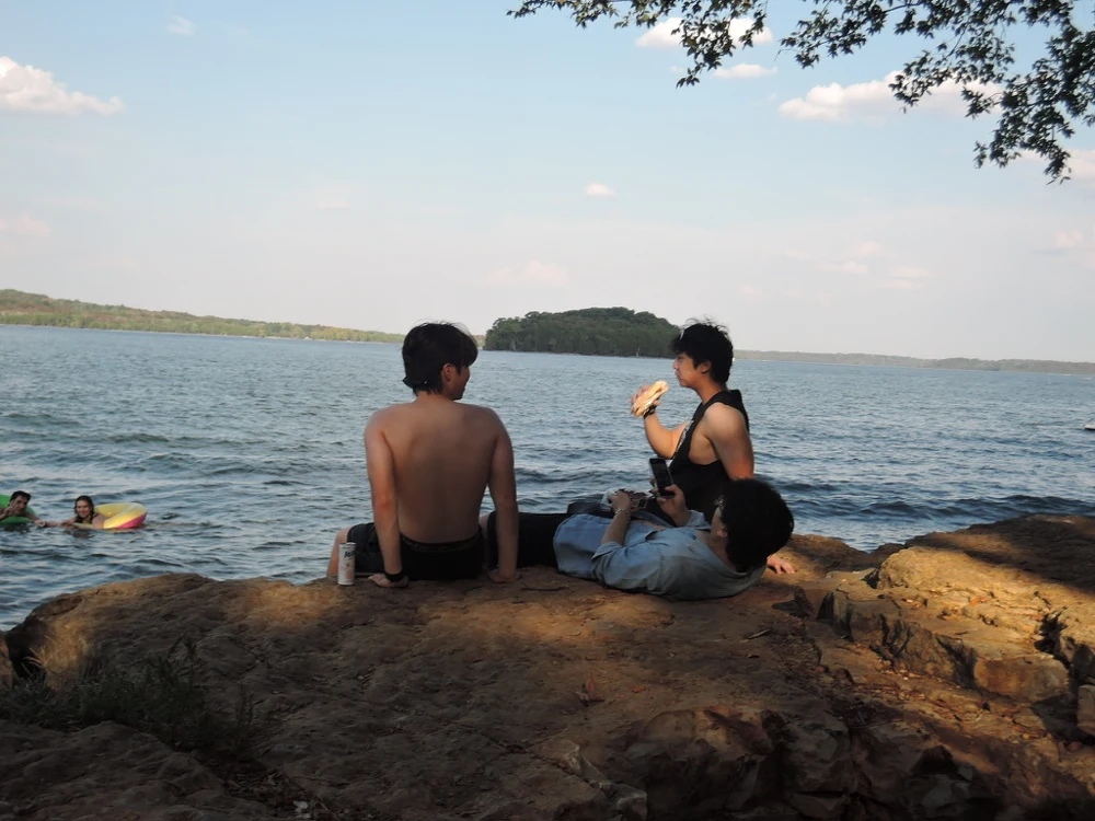 Friends relaxing on the rocks beside the lake