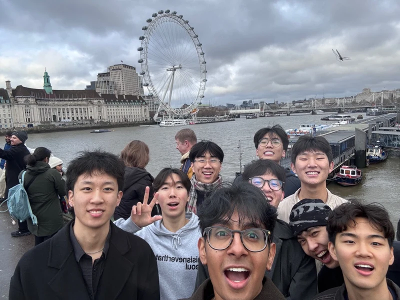 Friends beside the river with the London Eye behind them