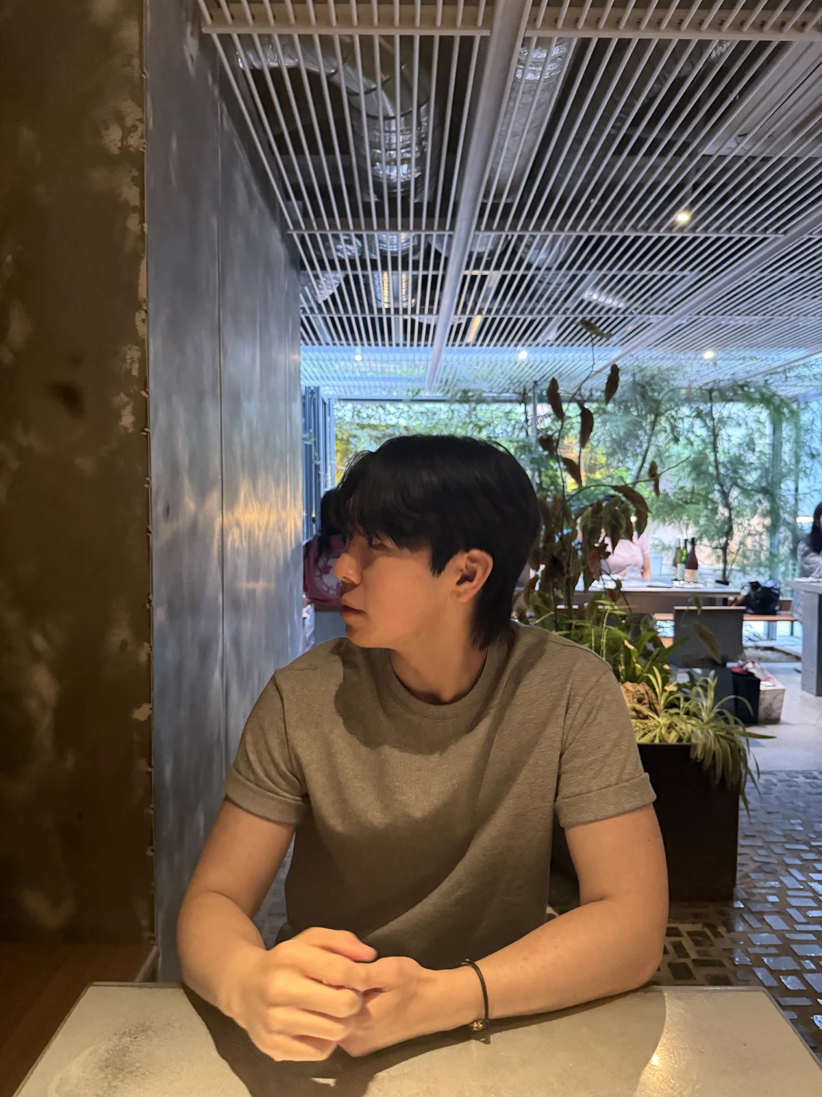 Jayden sitting at a café surrounded by plants
