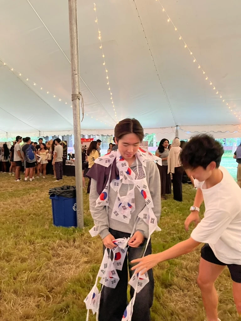 A playful moment with Korean flags at an outdoor gathering