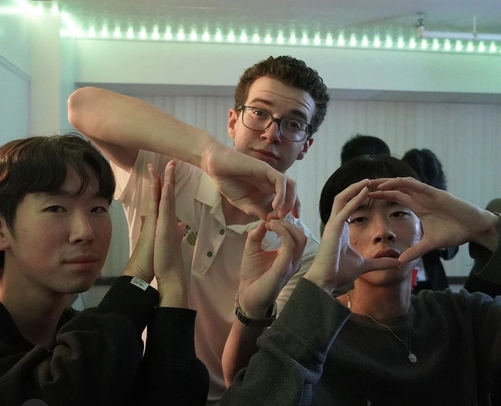 Three friends making hand gestures for a photo